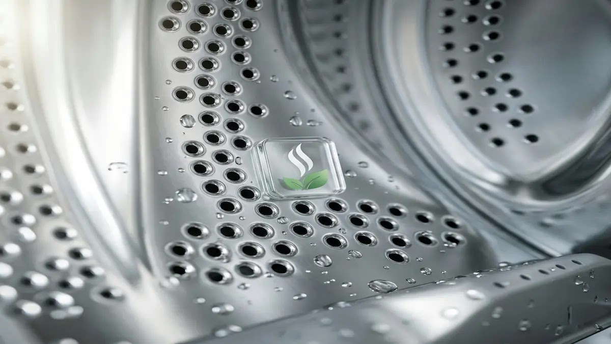 A close-up of a clean and shiny stainless steel washing machine drum, showing fresh and hygienic condition.