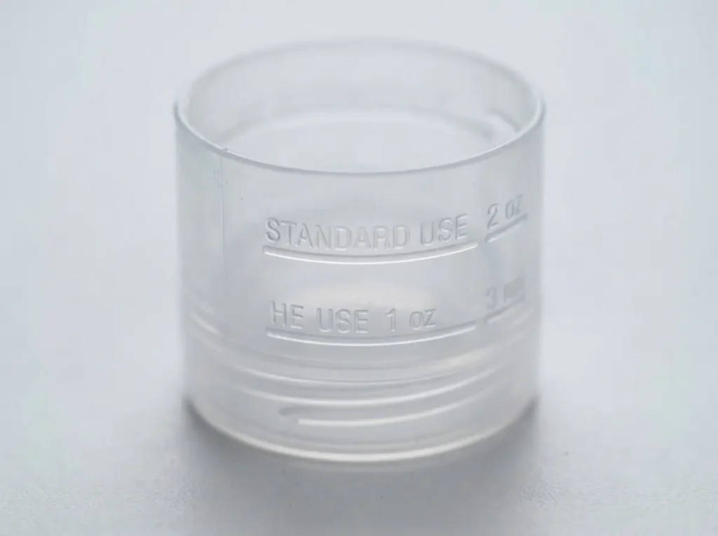 Detergent bottle cap showing separate HE dosing line